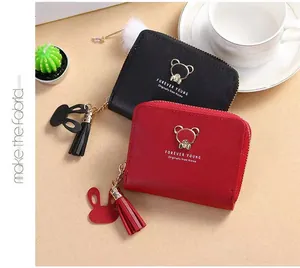 Close-up of leather coin purses with bear logo, tassel zippers and rabbit charms