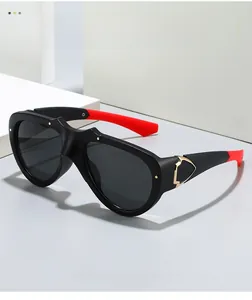 Detail of matte black sunglasses with red temple tips and gold metal hinge accents