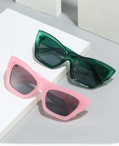 Detail view of pink and translucent green cat-eye sunglasses on geometric white blocks