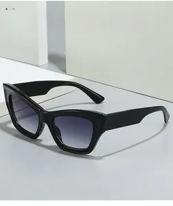 Detail of black cat-eye sunglasses with gradient purple lenses on a geometric display