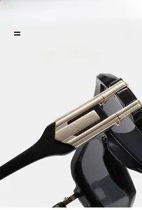 Detailed close-up of glossy black acetate sunglasses with golden metallic temple accents