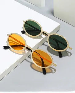 Detailed shot of oval metal sunglasses with gold textured frames and orange lenses