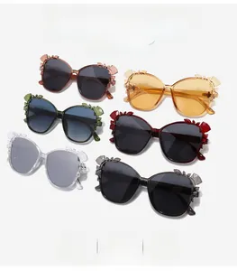 Detailed flat lay of cat eye sunglasses with crystal butterfly and floral decorations