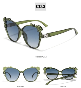 Detailed view of cat eye sunglasses with green crystal accents and blue gradient lenses