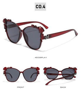 Three angles of red cat eye sunglasses with ruby crystal accents and smoke grey lenses