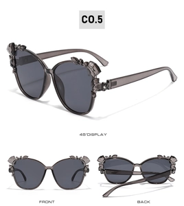 Cat-eye sunglasses with translucent grey frames and crystal embellishments on the edges