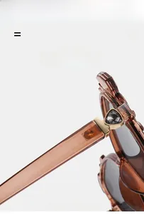 Detail of amber cat-eye sunglasses featuring black triangular gems and gold hardware