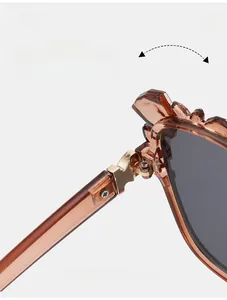 Macro detail of the durable golden metal hinge on amber cat-eye sunglasses frames
