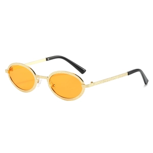 Retro oval sunglasses with golden textured metal frame and orange lenses on white background