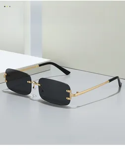 Detail of rimless rectangle sunglasses with grey lenses and gold metal temples
