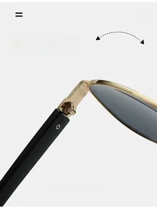 Detail of durable gold metal hinge on black vintage pilot sunglasses with gray lenses