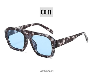 Detail view of square camouflage sunglasses with light blue lenses at 45 degree angle