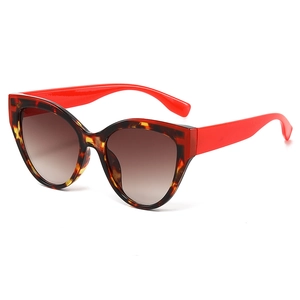 Fashionable cat eye sunglasses with tortoise frame and red temples on white background
