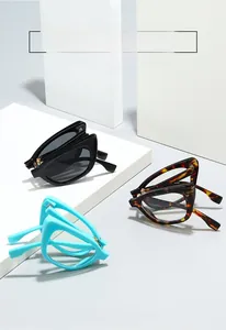 Detail showing foldable cat-eye sunglasses in black and tortoiseshell on stone blocks