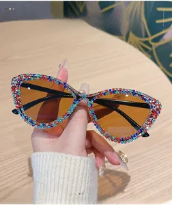Detail of cat-eye sunglasses with colorful rhinestones and tinted lenses on wood