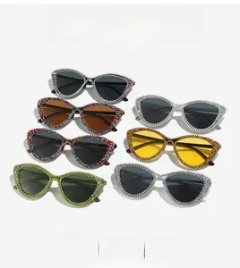 Flat lay of six rhinestone cat-eye sunglasses in various colors and sparkling crystal frames