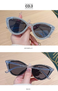 Detail of cat eye sunglasses featuring white pearls and rhinestones on wood background