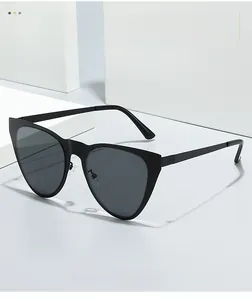 Detail view of black cat-eye sunglasses featuring metal hinges and dark UV lenses