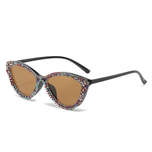 Cat eye sunglasses with colorful rhinestones and brown lenses on white background