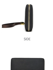 Détails de la texture du cuir litchi noir et fermeture éclair dorée sur un long portefeuille