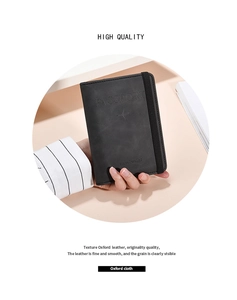 Detail of black Oxford leather passport holder with embossed logo and elastic strap