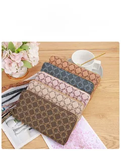 Multi-color canvas long zip wallets with geometric patterns and wrist straps on a table