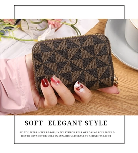 Brown geometric patchwork card wallet with gold zipper shown in a cozy lifestyle setting