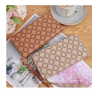 Lifestyle shot of dual zip wallets in brown and beige with circular chain patterns
