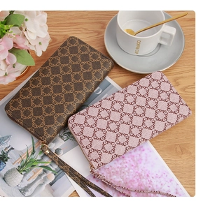 Detail of pink and brown leather clutches with geometric patterns on a wooden table