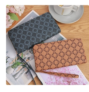 Detail of long zippered wallets with wristlets in charcoal and tan geometric patterns