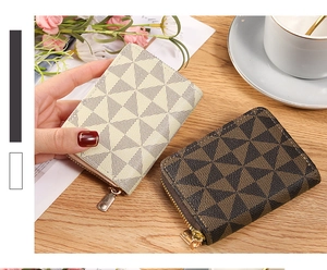 Detail of zipper card wallets with geometric patterns on a wooden table with decor