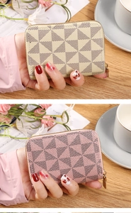 Detail of pink and beige mini coin purses with geometric patterns and metal zippers