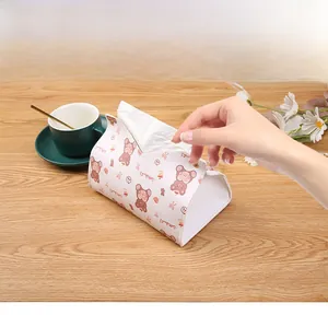 Detail of white PU leather tissue box with brown cartoon bear pattern on wooden desk