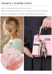 Pink lychee leather mini pouch with silk scarf detail hanging on a luxury handbag