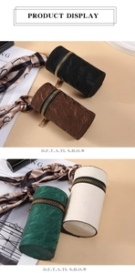 Detailed view of cylindrical coin purses with metal zippers and decorative scarves