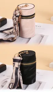 Detail of cylindrical mini pouch with gold zipper and stylish printed silk ribbon