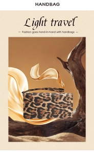 Detail of leopard print clutch handbag with textured leather finish and wrist strap