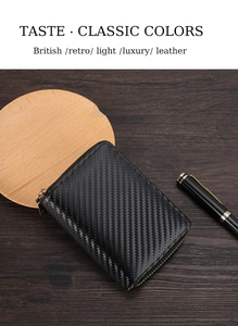 Close-up of black carbon fiber texture wallet on wooden desk with metal zipper detail