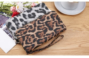 Detailed view of leopard print long zip wallets in brown and silver with wrist straps