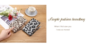 Detailed view of long zip wallets with leopard print patterns and wrist straps on a desk