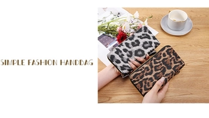Detail of leopard print long wallets with metal zippers on a wooden table setup