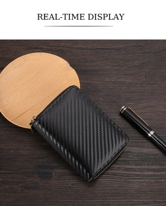 Close-up of black carbon fiber texture wallet with durable metal zipper on a wooden desk
