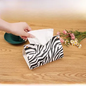 Close-up of zebra pattern leather tissue box with gold snap button and smooth paper extraction