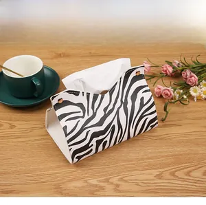 Top view of zebra pattern PU leather tissue box holder on a wooden table with coffee cup