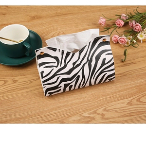 Zebra print PU leather tissue box cover with V-opening and bronze snaps on wooden table