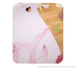 Macro shot of pink marble texture leather tissue box with white stitching and gold rivet