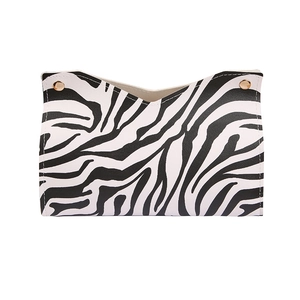 Nordic zebra print leather tissue box with elegant gold metal buckles on a white background