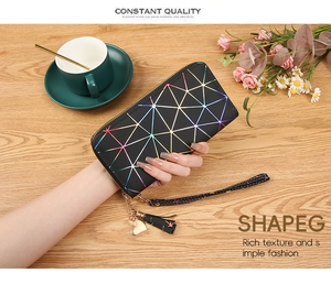 Detailed close-up of a long zip-around wallet with iridescent geometric patterns and wristlet