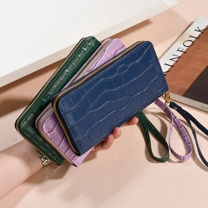 Three crocodile embossed zip wallets in navy, lilac, and green with leather wrist straps