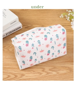 Detail of floral rectangular leather tissue box with white zipper on wooden desk